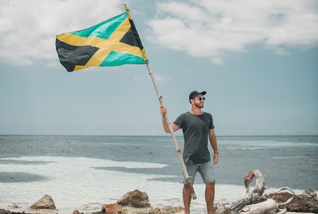 man with Jamaican flag at beach